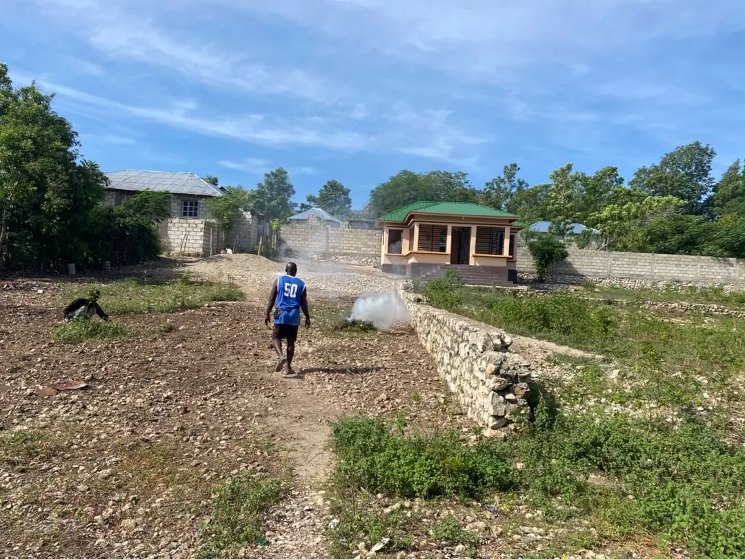 A stone path leading to a small green-roofed building in the community