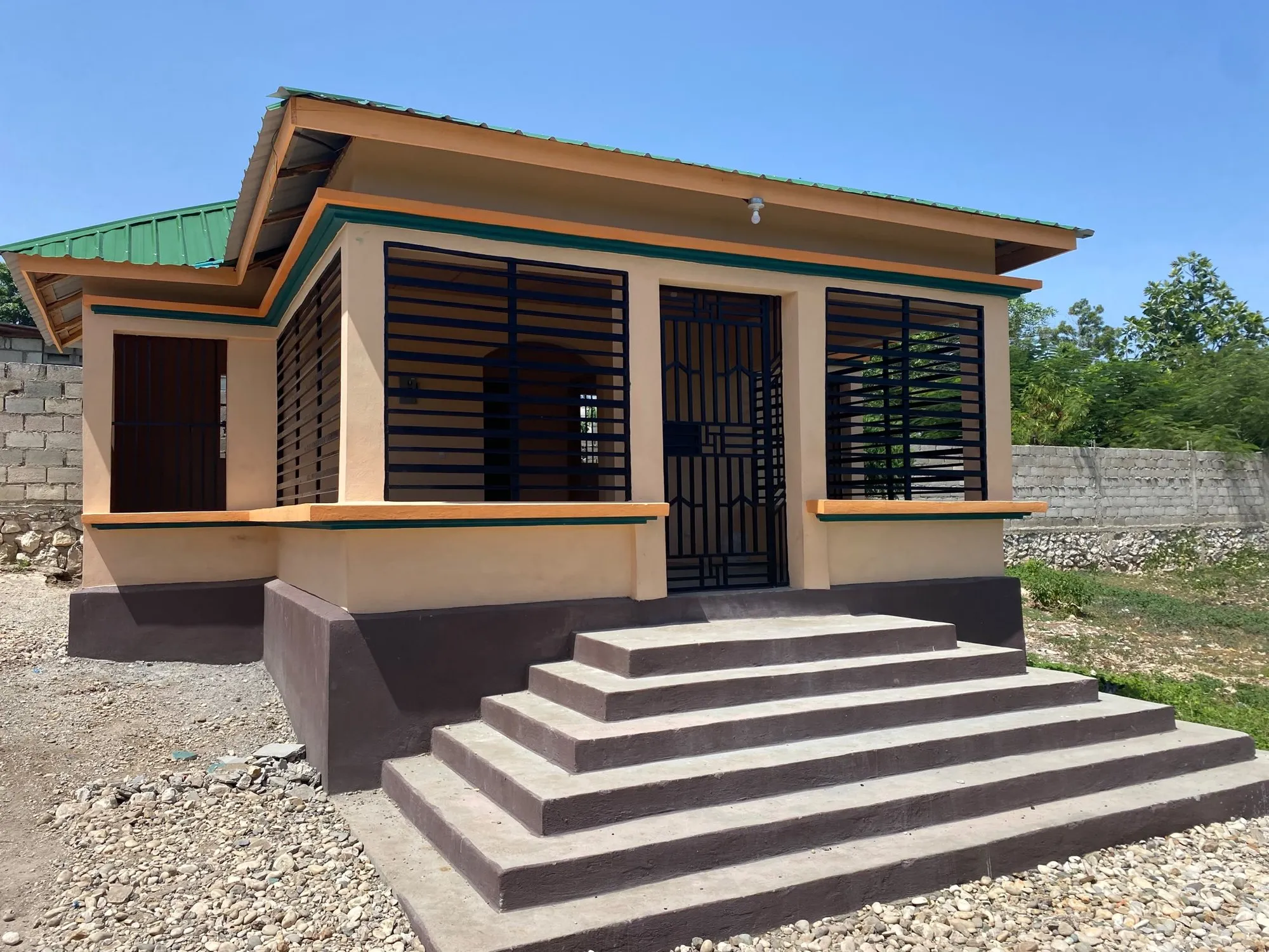 The new House of Hope counseling building in Deschapelles, with its green roof, orange trim and front steps