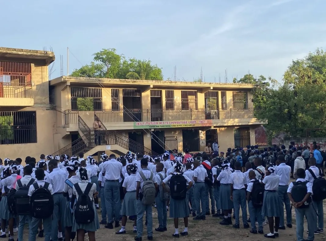 Students in school uniforms gathered for an assembly outside their school in Deschapelles