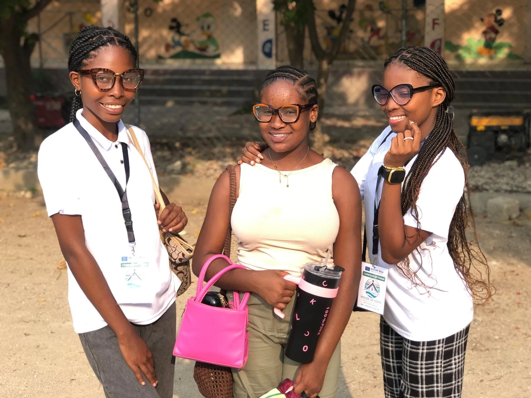Three smiling volunteers wearing House of Hope name badges